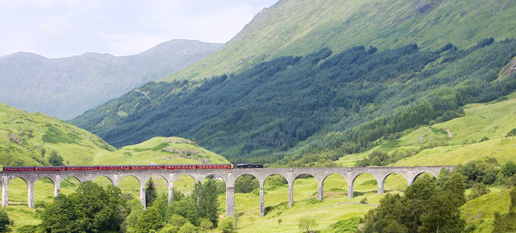 Steam train crossing the Glenfinnan Viaduct in the Scottish Highlands